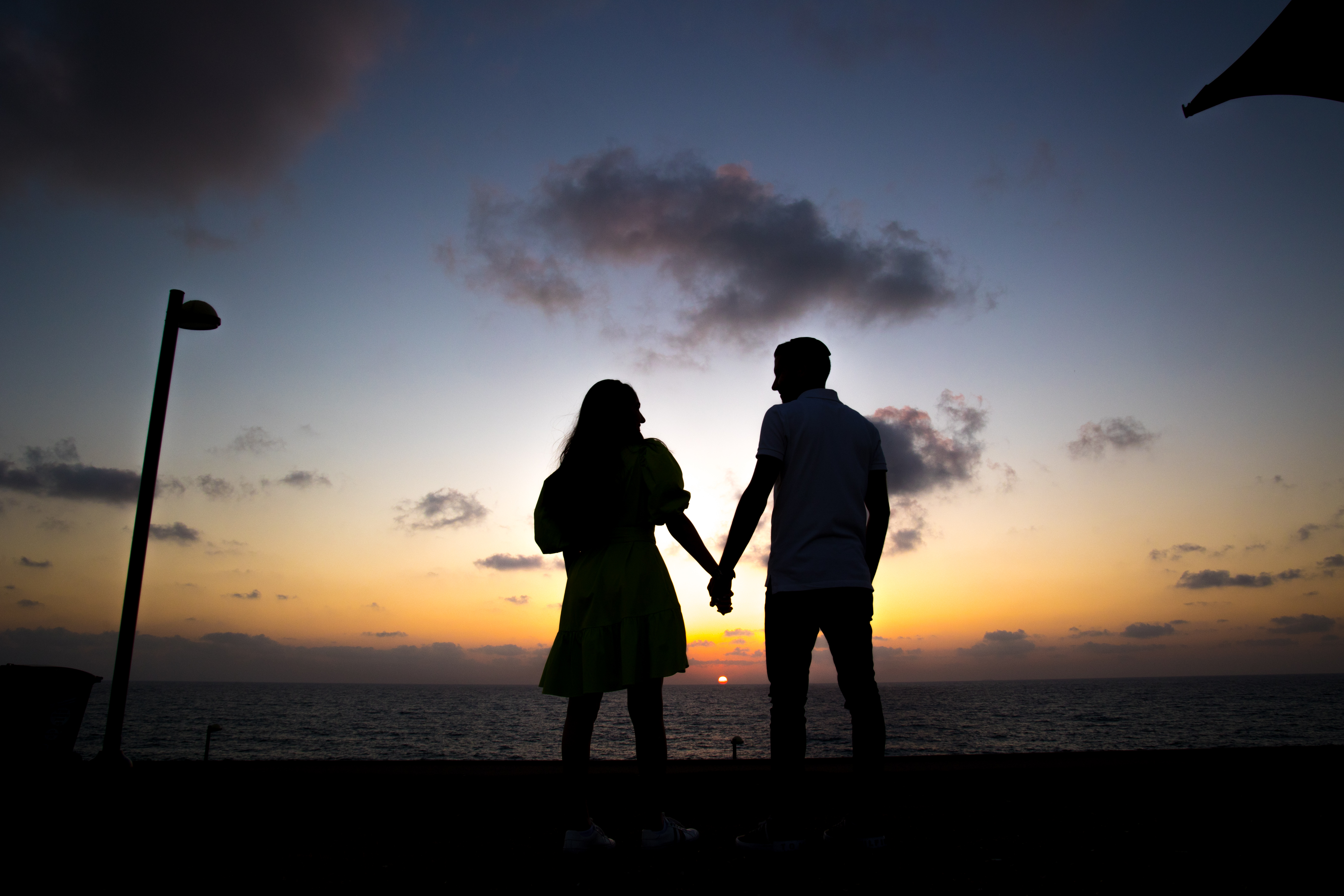 A couple holding hands at sunset